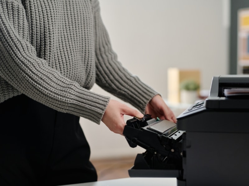 hp deskjet 3700 ink cartridge replacement as person opens printer to check low ink cartridge.